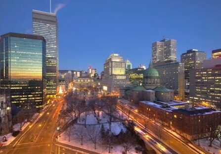 A city skyline with buildings and street lights.